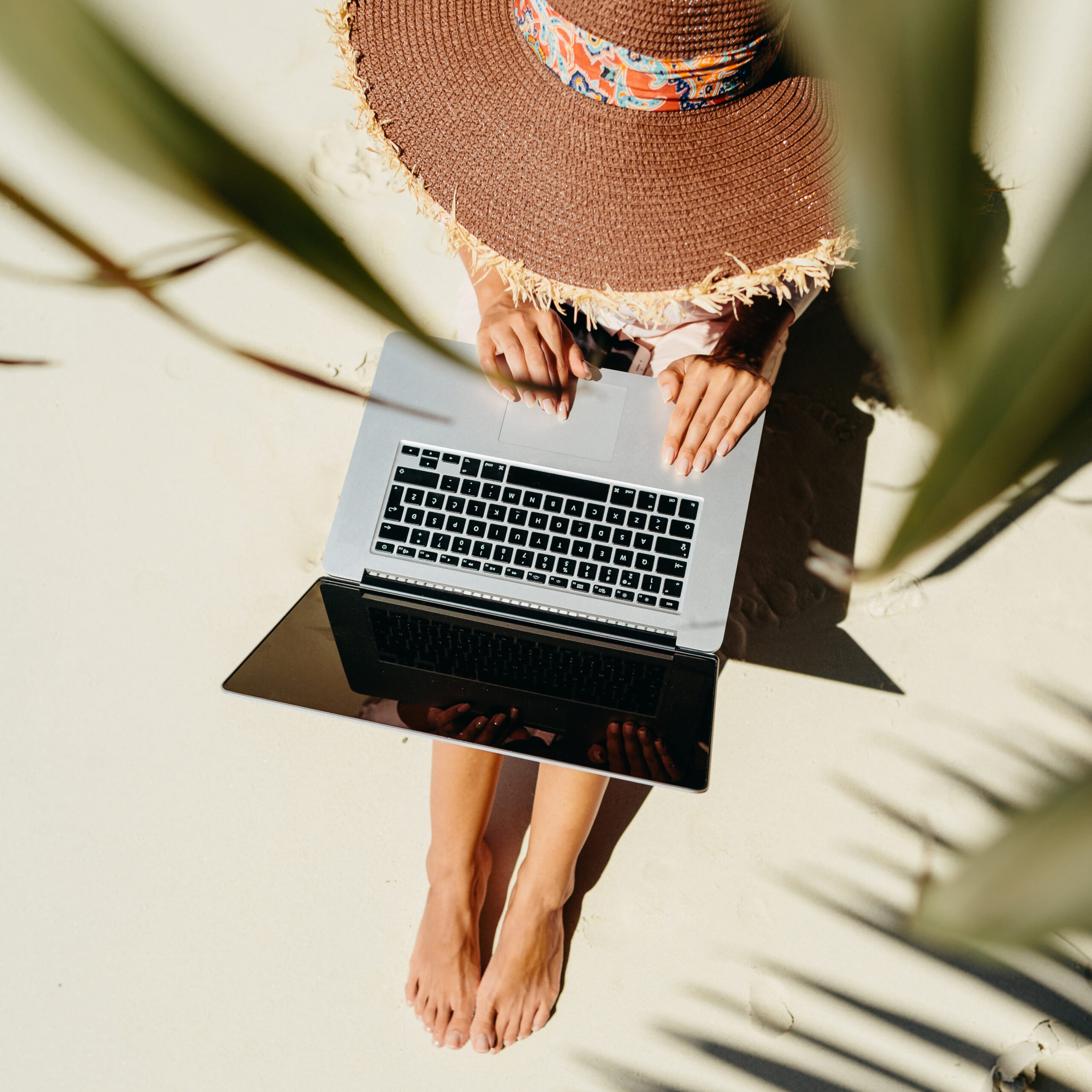 beautiful Hispanic woman working on laptop and drinking coffee in the balcony
